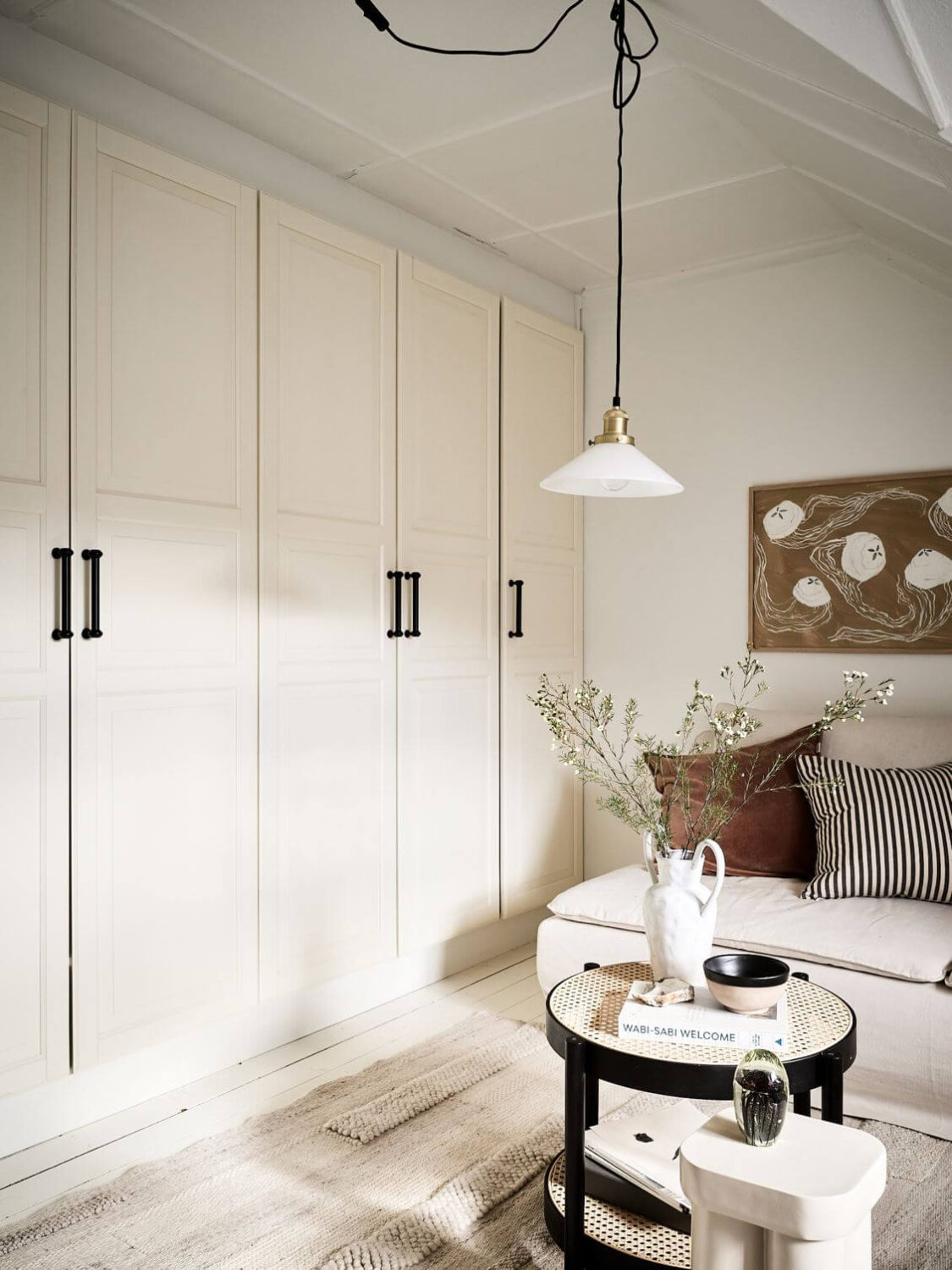 A White Scandinavian Attic Apartment 3 built-in-cabinets-small-living-room-slanted-ceiling-nordroom