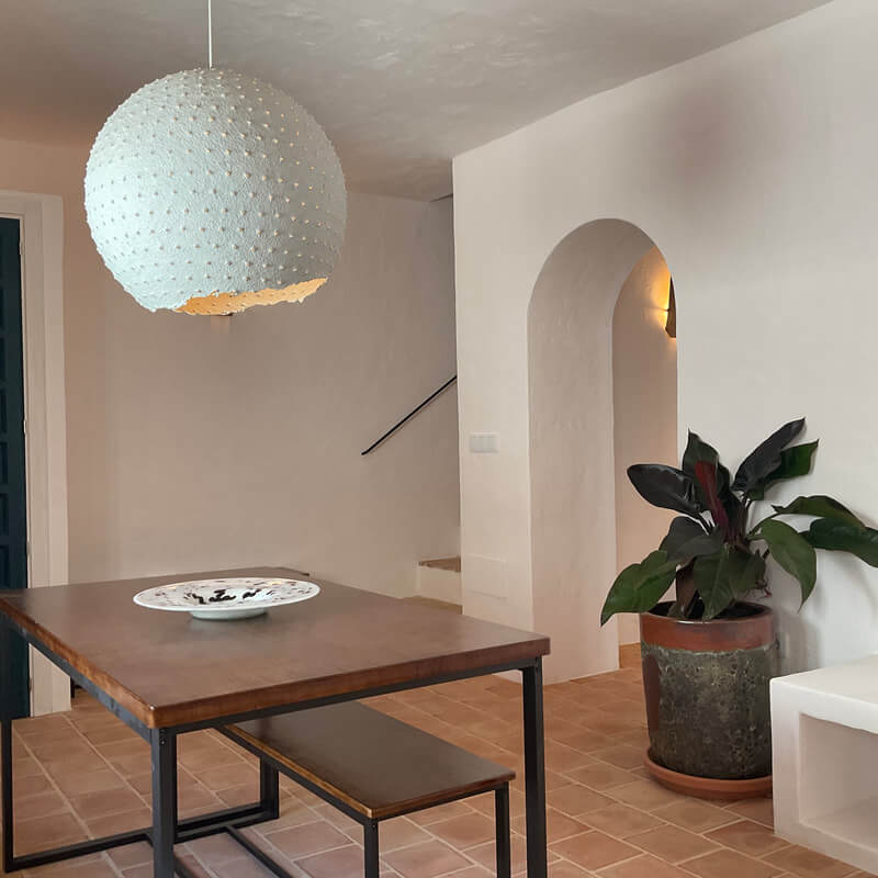 Casita Alborán: A Stylish Home in a Spanish Seaside Town 5 dining-table-living-room-arched-doorway-terracotta-floor-tiles-nordroom