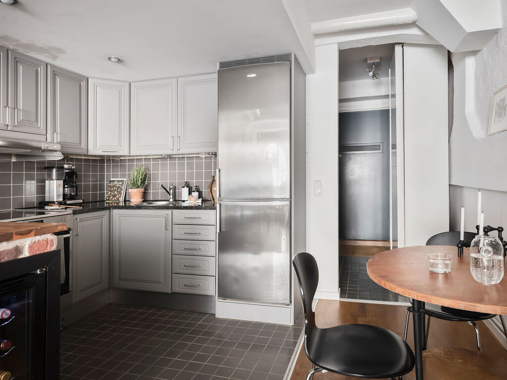 A Scandinavian Loft with Brick Wall and Arched Window 18 gray-kitchen-cabinets-small-round-table-nordroom