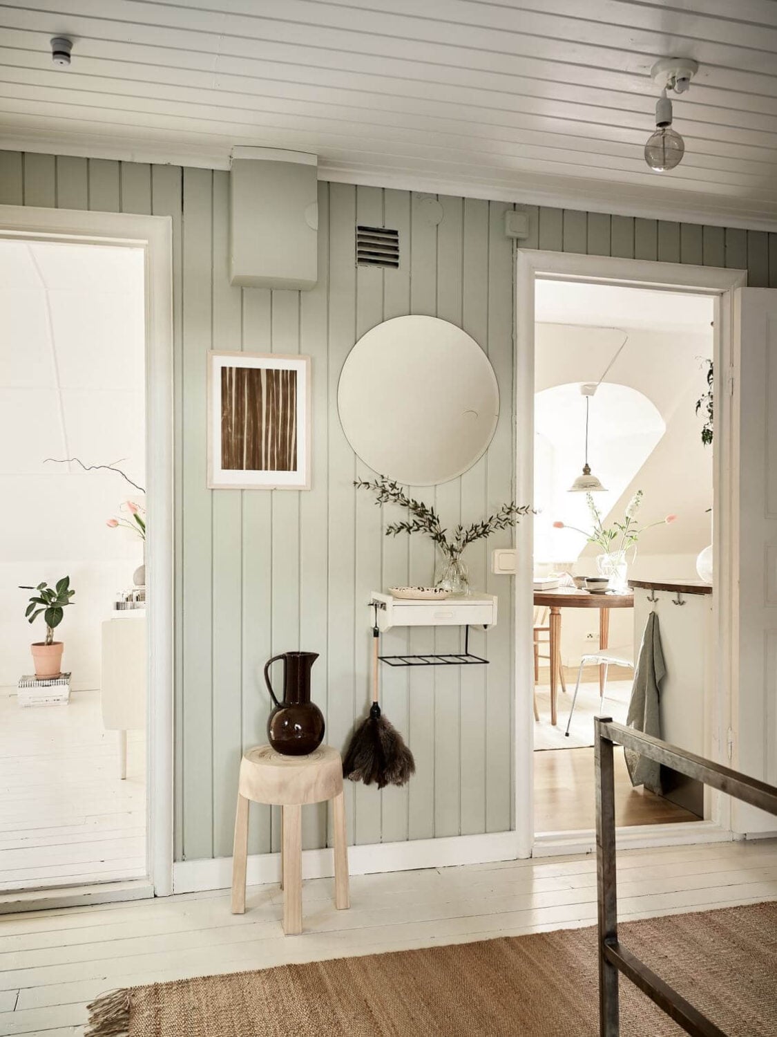 A White Scandinavian Attic Apartment 6 hallway-jute-rug-mint-green-wood-paneled-walls-nordroom