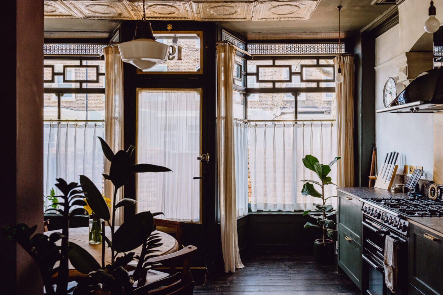 A Victorian Watch Shop is Now a Warm Sustainable Home 3 kitchen-historic-shop-windows-dark-green-cabinets-nordroom