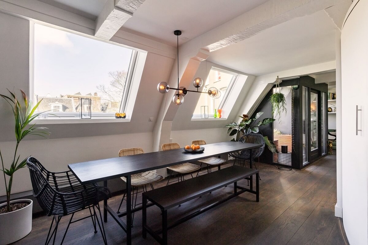 An Amsterdam Penthouse with Green Color Accents 10 large-black-dining-table-slanted-ceiling-nordroom