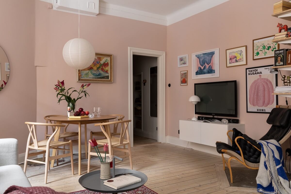 A Pink Living Room in a Scandinavian Apartment 1 pink-walls-living-room-round-dining-table-wooden-floor-art-nordroom