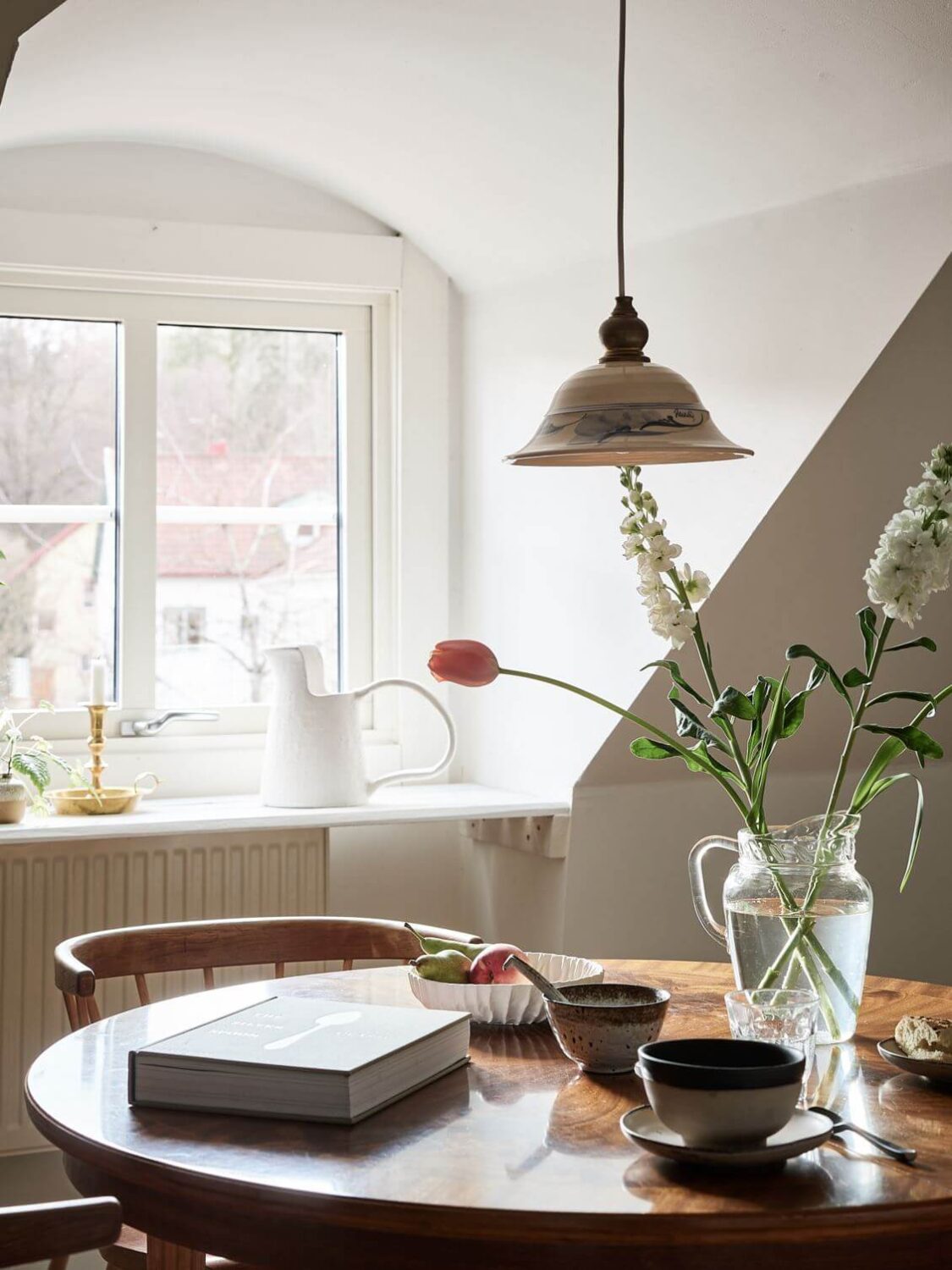 A White Scandinavian Attic Apartment 16 round-wooden-dining-table-light-attic-apartment-nordroom