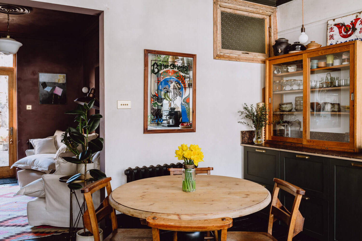 A Victorian Watch Shop is Now a Warm Sustainable Home 4 round-wooden-kitchen-table-green-kitchen-cabinets-nordroom