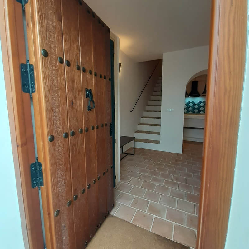 Casita Alborán: A Stylish Home in a Spanish Seaside Town 26 rustic-wooden-front-door-stone-floor-hallwa-nordroom