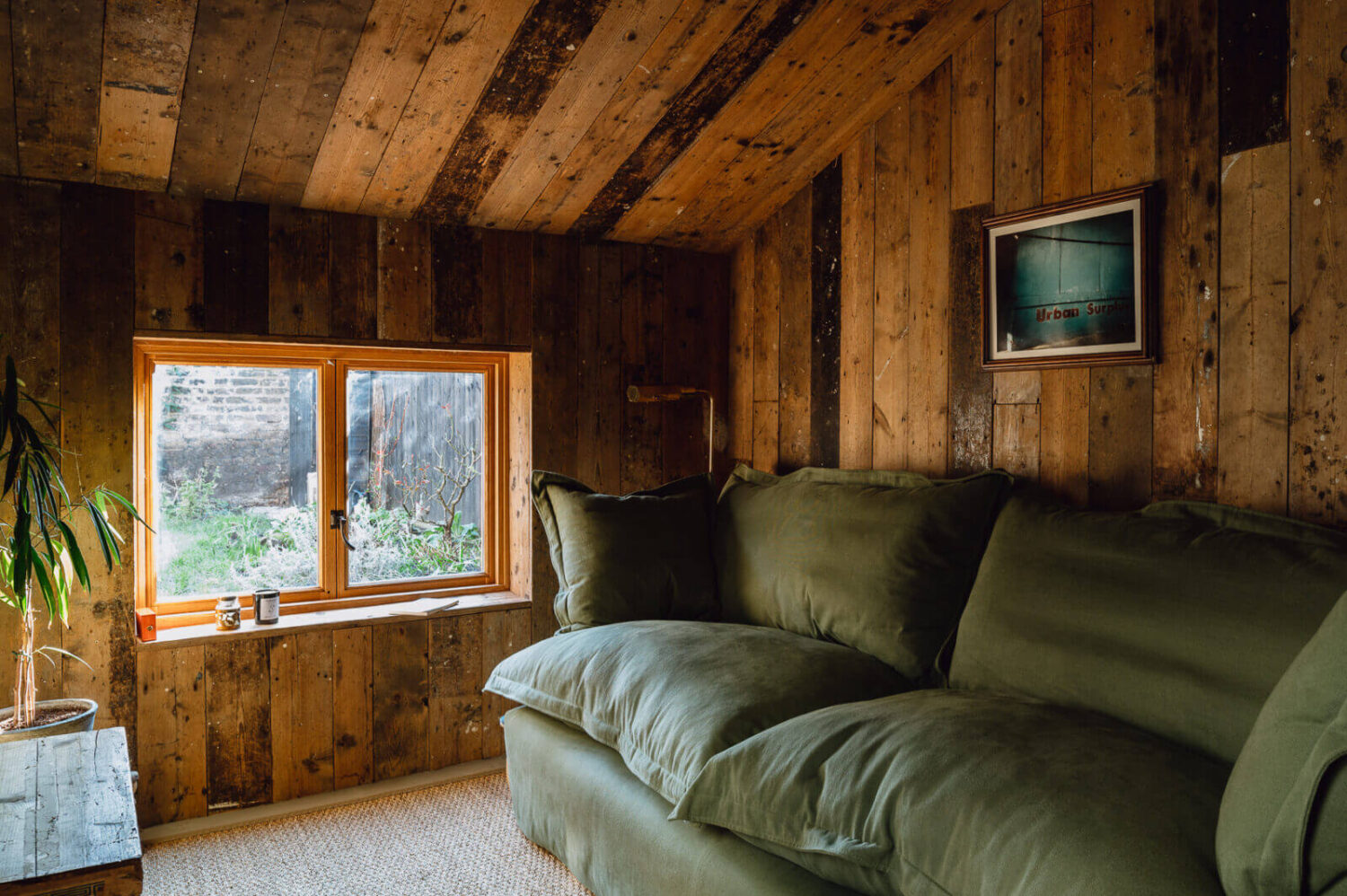 A Victorian Watch Shop is Now a Warm Sustainable Home 11 sitting-room-reclaimed-timber-walls-green-maker-and-son-sofa-nordroom
