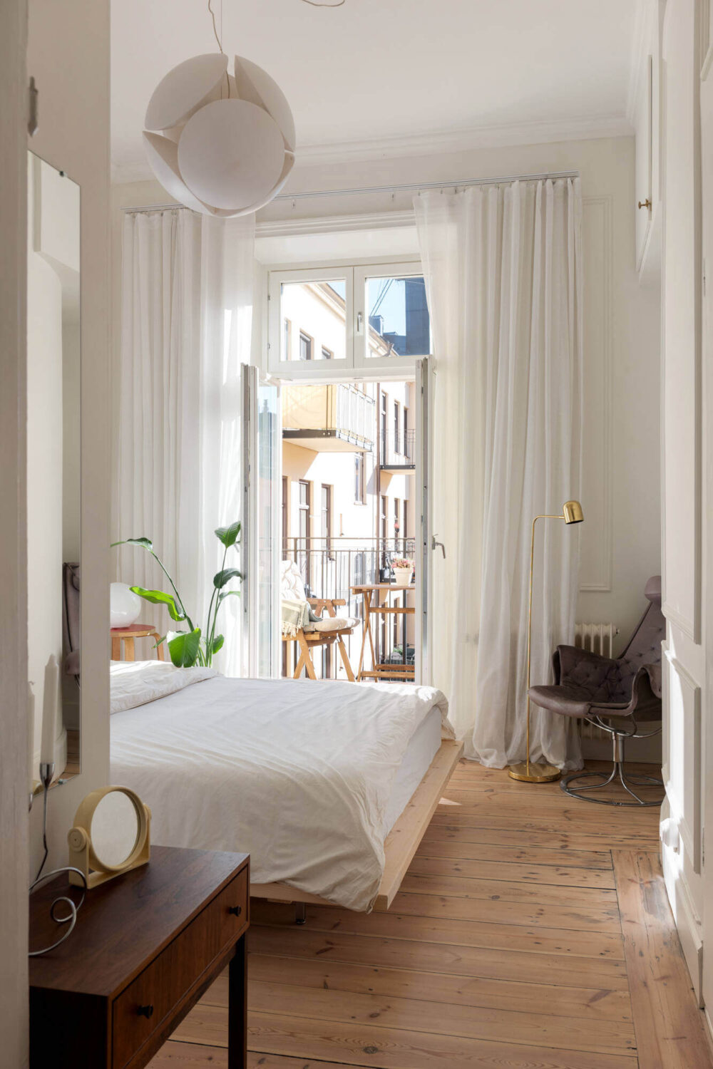 A Small Stockholm Apartment with Lovely Natural Light 10 white-bedroom-balcony-wooden-floarboards-nordroom