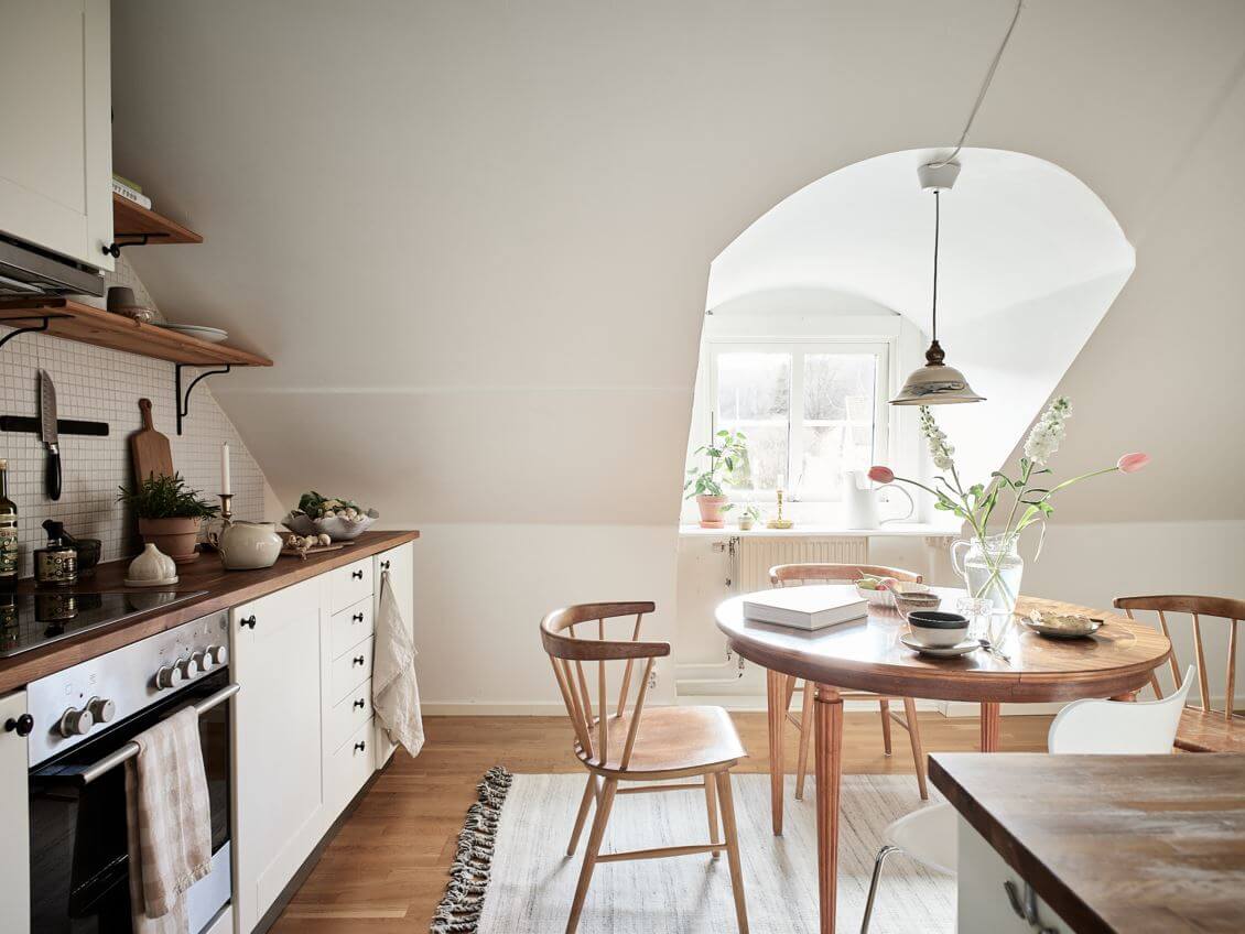A White Scandinavian Attic Apartment 15 white-kitchen-round-wooden-dining-table-slanted-walls-nordroom