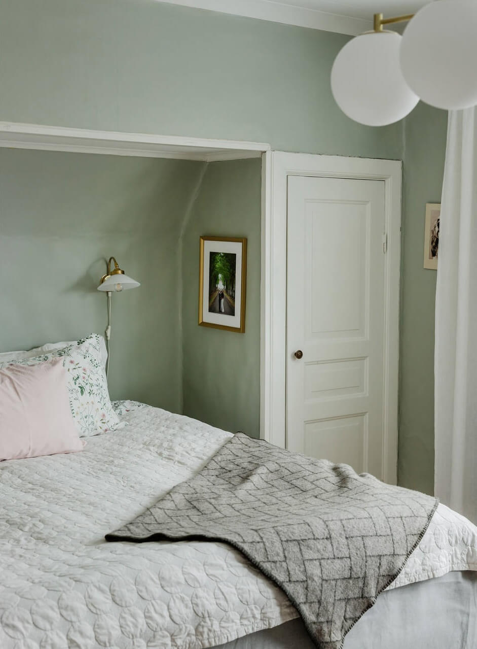 Green Tones and Wallpaper in a Charming Swedish Home 14 bed-niche-master-bedroom-light-green-walls-built-in-wardrobes-nordroom