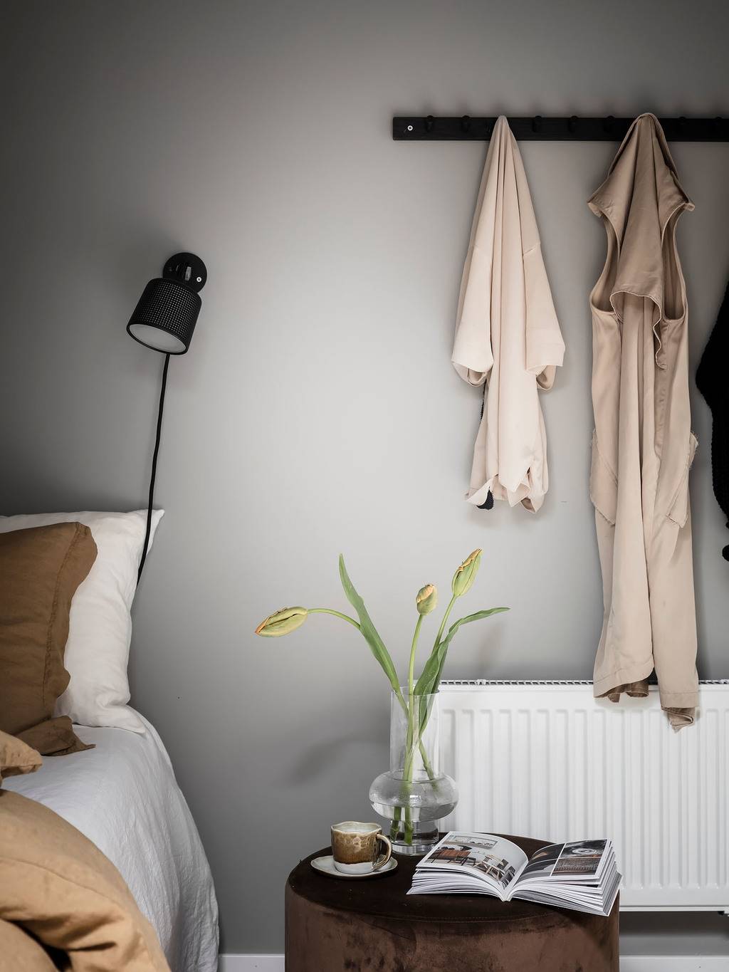 A Small Gray Attic Apartment in Sweden 14 bedroom-detail-gray-walls-wooden-bedside-table-hooks-nordroom