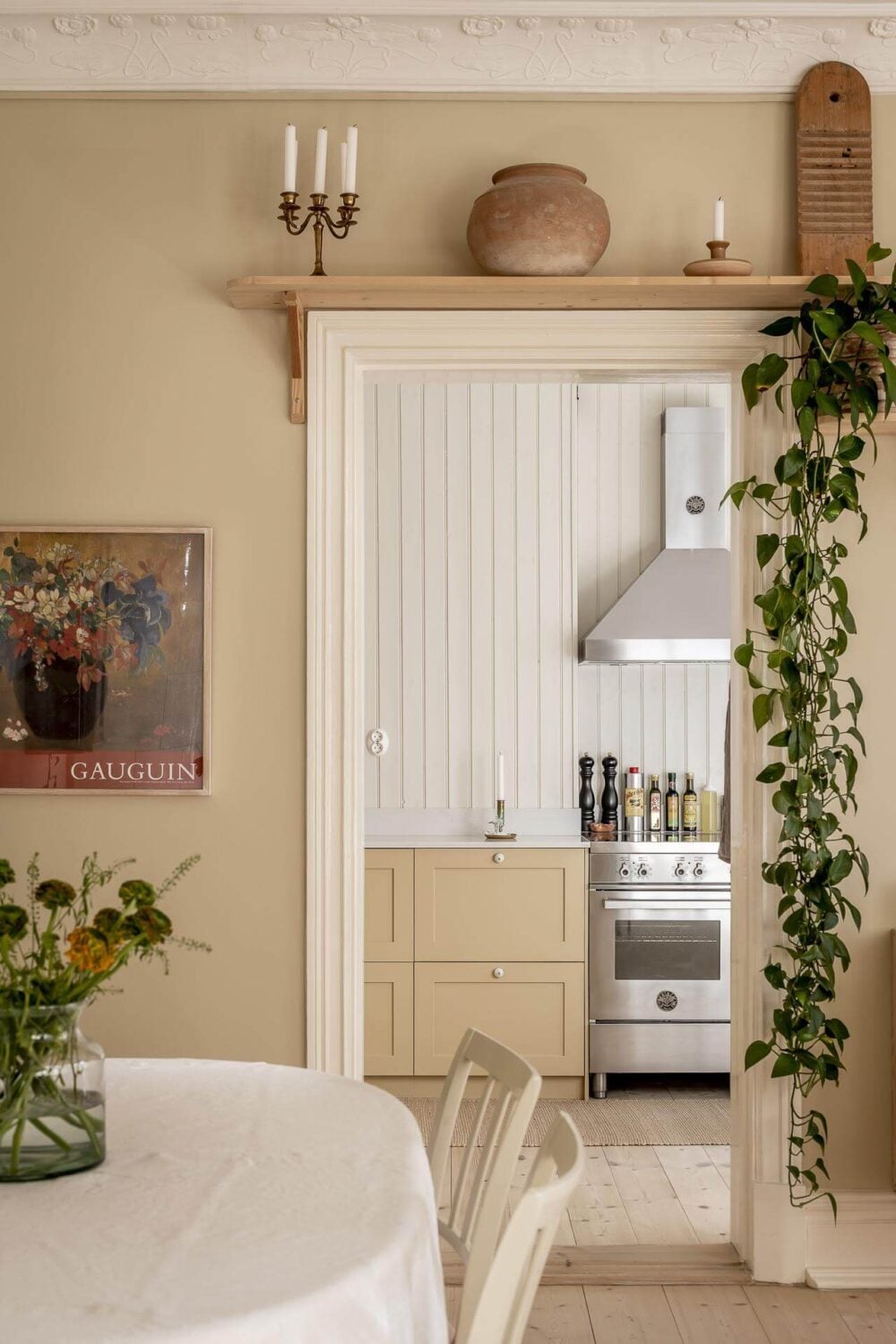 A Scandinavian Apartment with a Pale Yellow Kitchen 11 beige-walls-wooden-shelf-above-door-kitchen-nordroom