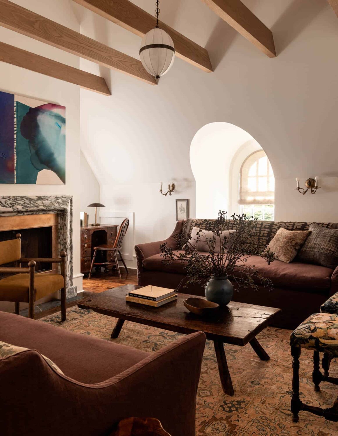 A Cozy Pied-à-Terre with Slanted Ceilings and Wallpaper 14 heidi-caillier-living-room-purple-couch-exposed-wooden-beams-nordroom