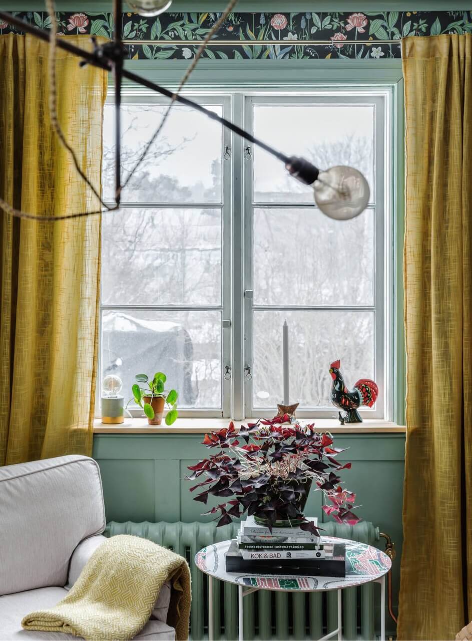 Green Tones and Wallpaper in a Charming Swedish Home 8 living-room-detail-armchair-yellow-curtains-nordroom