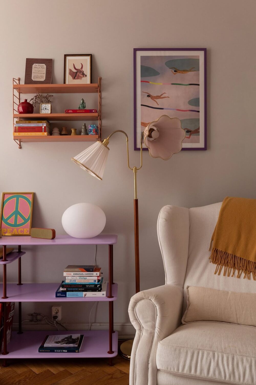 A Serene Nordic Apartment with Pink Color Accents 15 living-room-white-armchair-purple-shelf-light-gray-wall-paint-nordroom