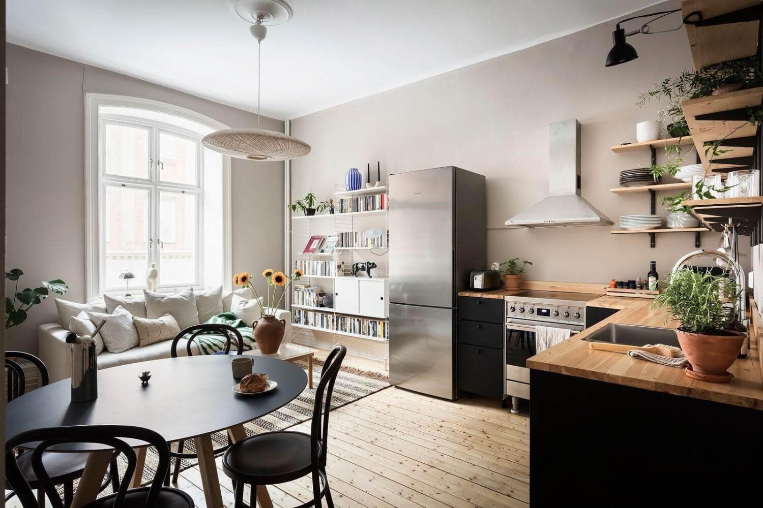 A Stylish Nordic Apartment with a Pink Bedroom 1 open-plan-living-room-kitchen-black-cabinets-nordroom
