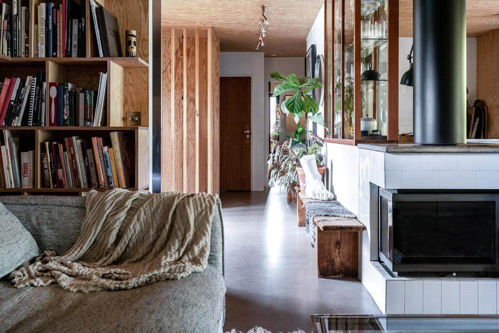 A Renovated Sustainable Home in Sweden 6 open-plan-living-space-concrete-floor-fireplace-bookshelves-nordroom