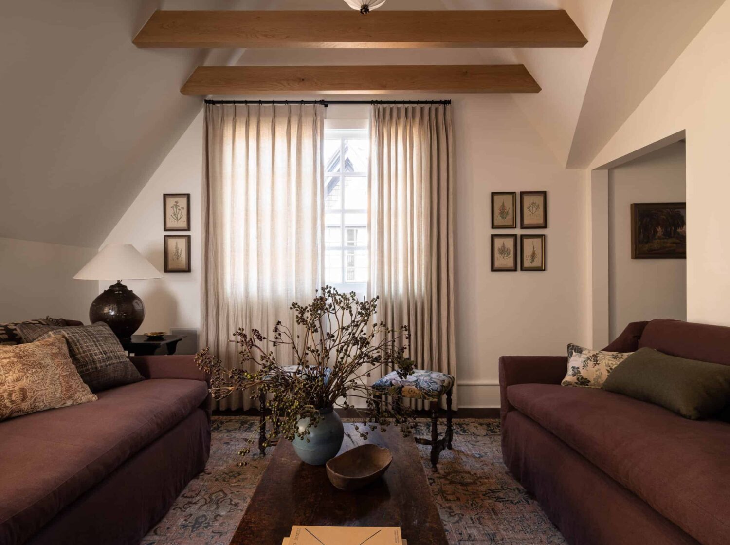 A Cozy Pied-à-Terre with Slanted Ceilings and Wallpaper 15 slanted-ceiling-exposed-wooden-beams-living-room-nordroom