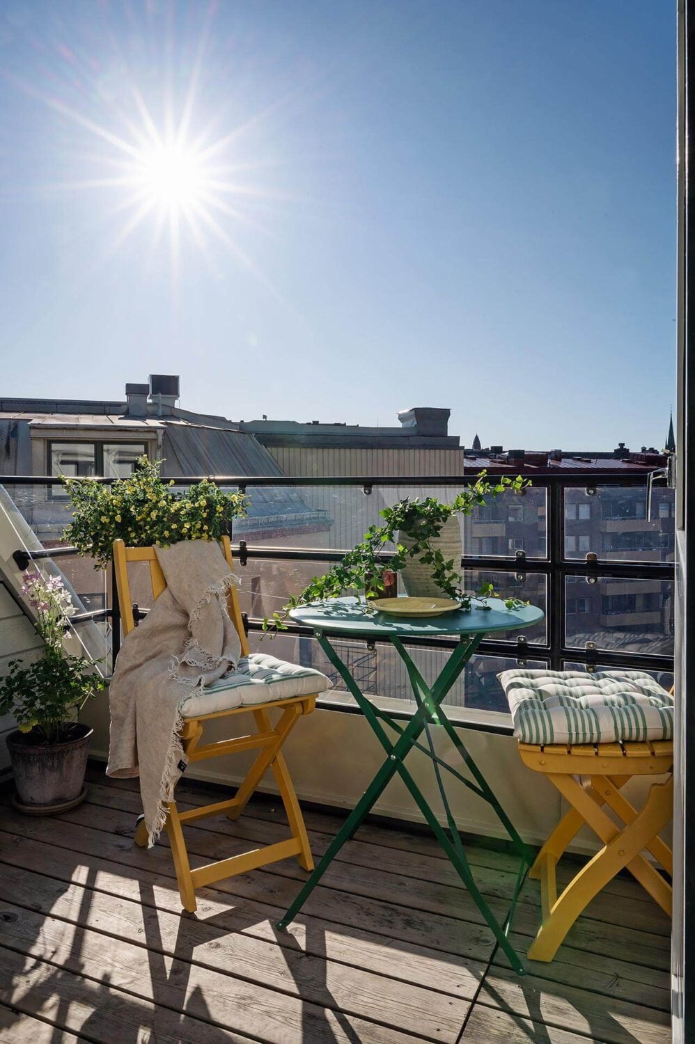 A Modern Scandinavian Attic Apartment 19 balcony-green-table-yellow-bistro-chairs-nordroom