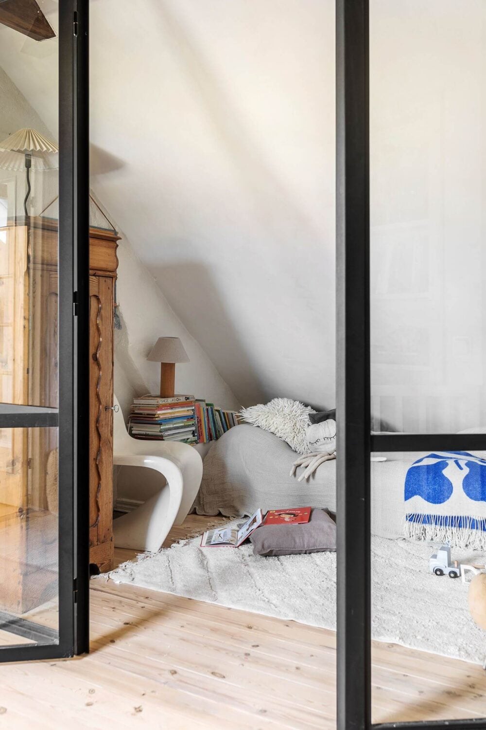 A Charming Attic Apartment with High Ceilings 14 bedroom-sloped-ceiling-steel-glass-wall-nordroom