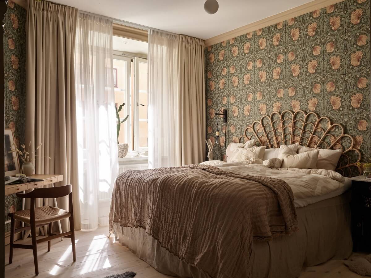 Warm Muted Colors in a Stockholm Apartment 11 bedroom-with-home-office-william-morris-wallpaper-rattan-headboard-nordroom