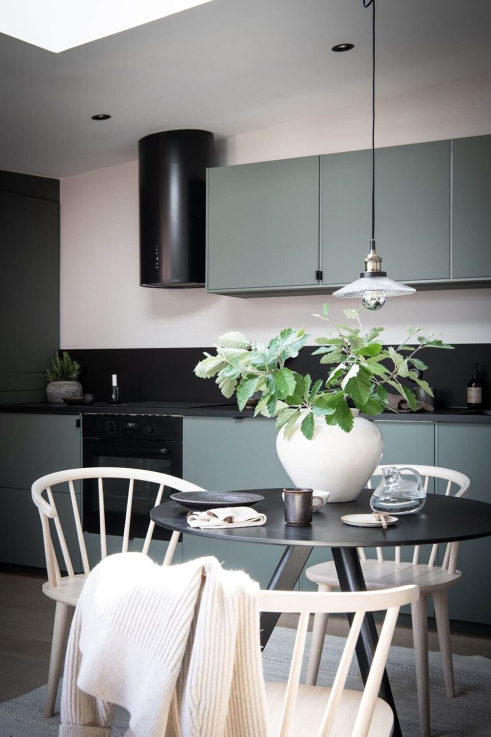 A Stylish Scandinavian Attic Apartment 8 dining-table-round-green-modern-kitchen-skylight-nordroom