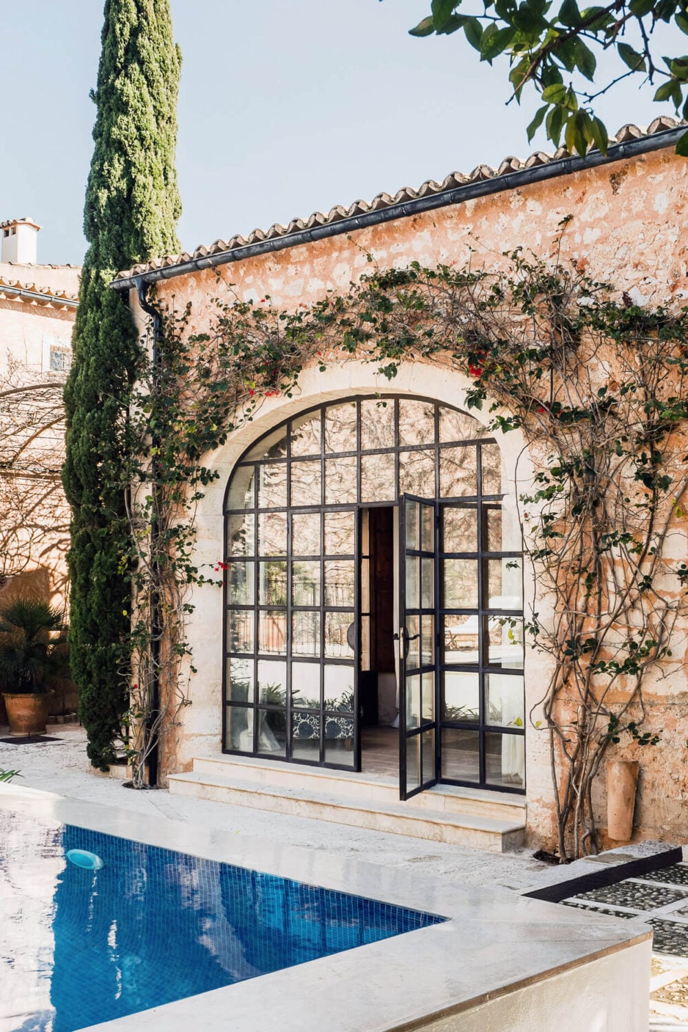 A Renovated Historic Townhouse on Mallorca 25 garden-entry-steel-glass-arched-window-nordroom