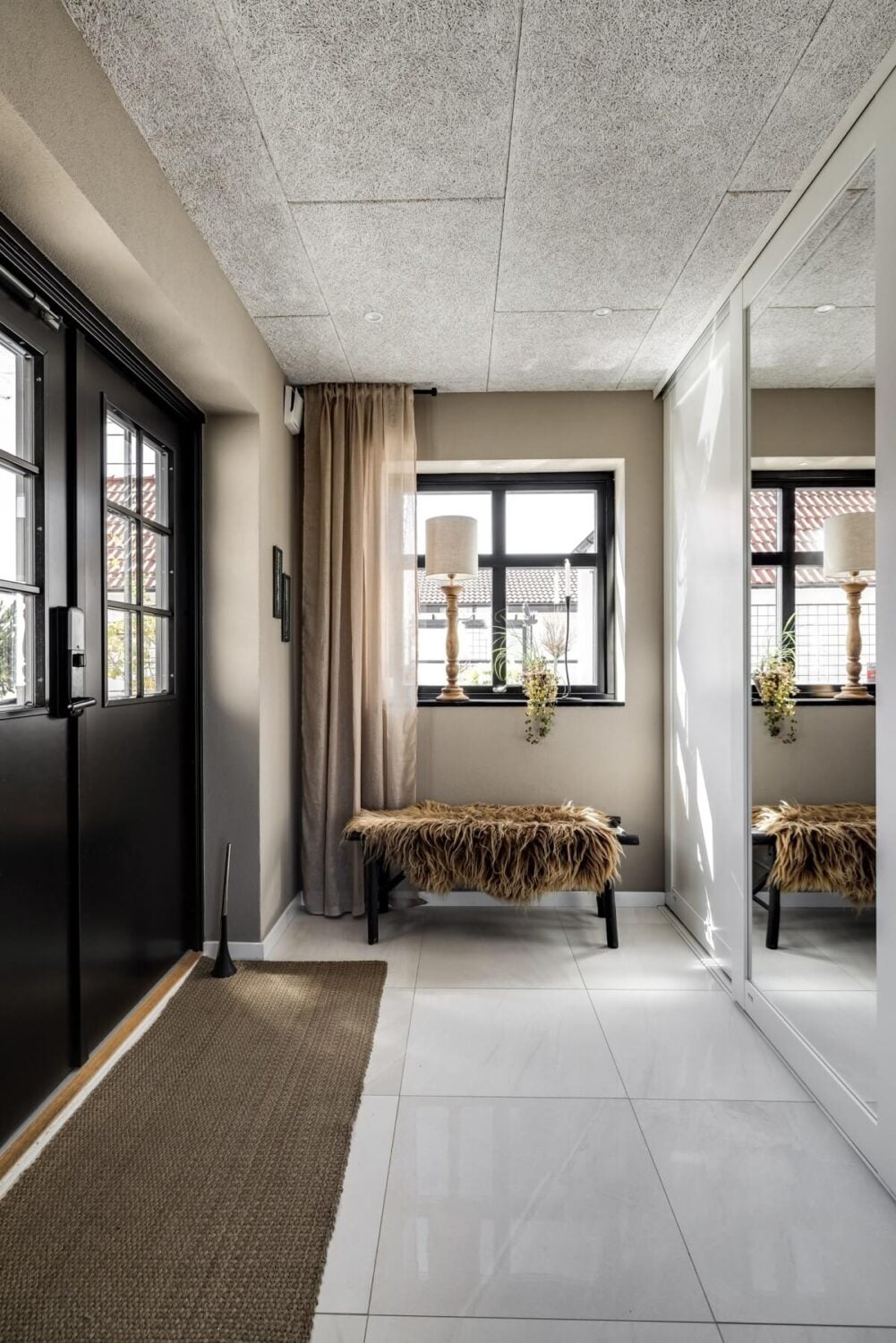 A Monochrome Swedish Villa with High Ceilings 25 hallway-double-black-door-bench-nordroom