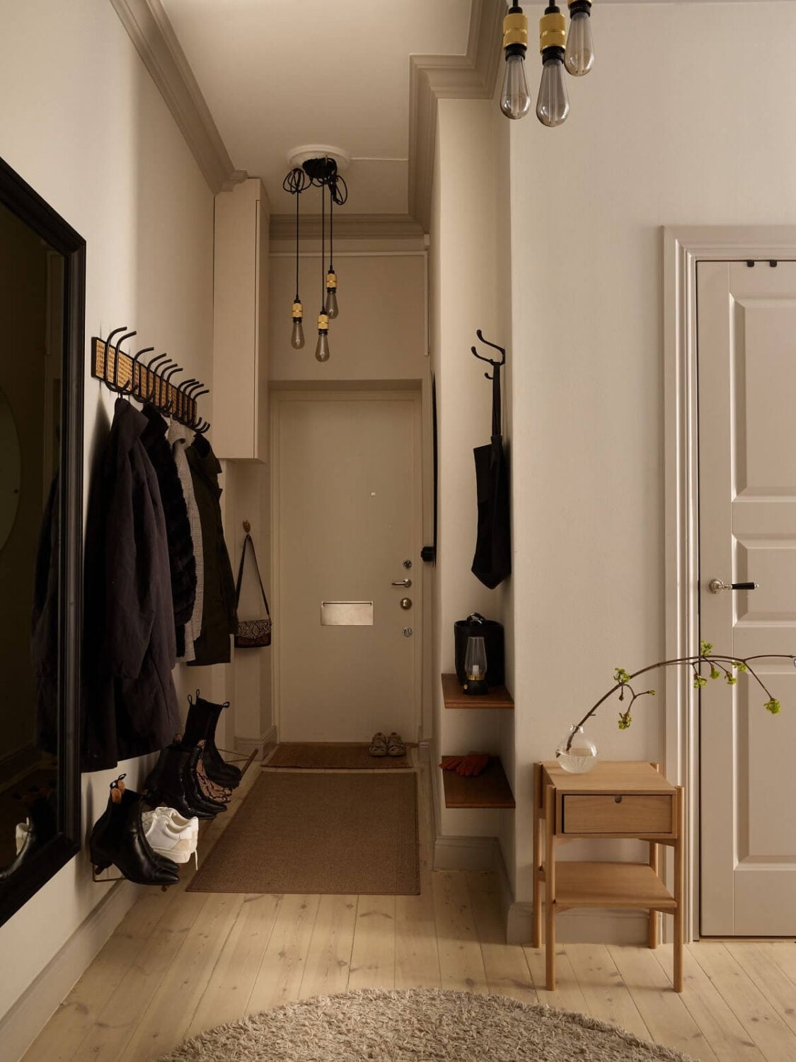 Warm Muted Colors in a Stockholm Apartment 18 hallway-storage-round-rug-wooden-floor-nordroom