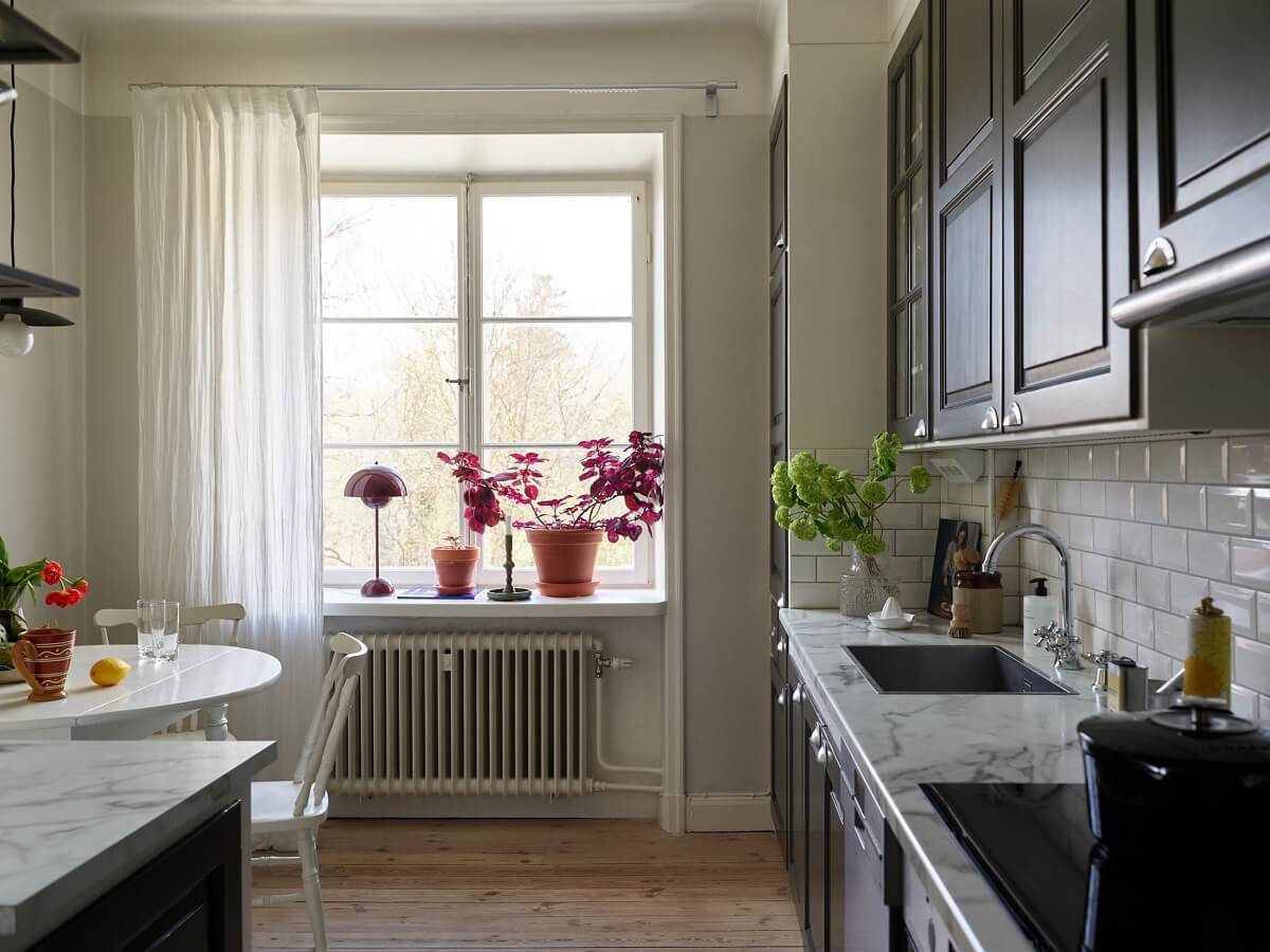 A Scandinavian Apartment with a Light Green Bedroom 9 kitchen-dark-gray-cabinets-wooden-floor-nordroom