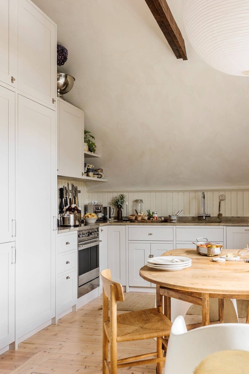 A Charming Attic Apartment with High Ceilings 2 kitchen-light-gray-cabinets-slanted-ceiling-exposed-beams-nordroom