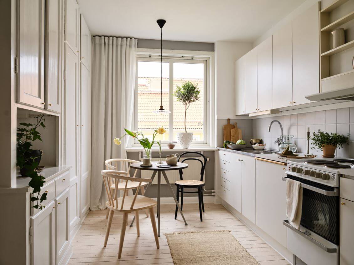 A Warm Beige Studio Apartment in Sweden 10 kitchen-studio-apartment-gray-walls-white-cabinets-small-round-dining-table-nordroom