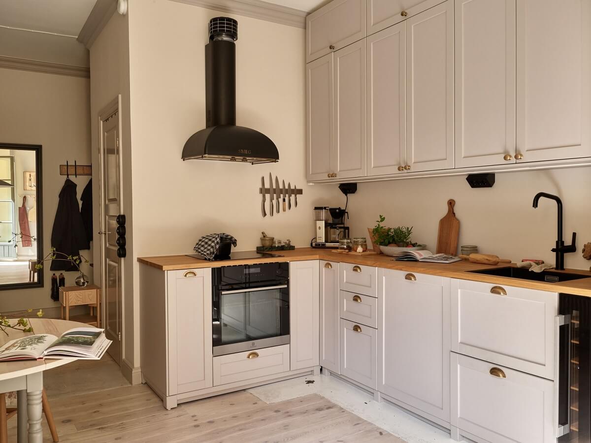 Warm Muted Colors in a Stockholm Apartment 10 kitchen-white-cabinets-wooden-worktop-beige-walls-nordroom