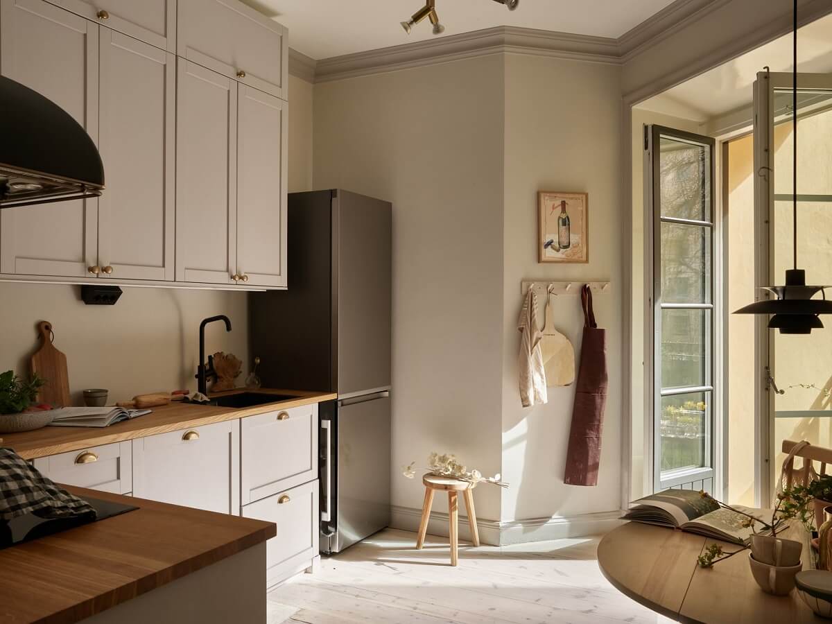Warm Muted Colors in a Stockholm Apartment 6 l-shaped-kitchen-small-table-balcony-nordroom