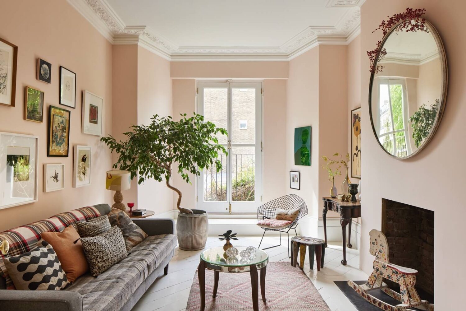 living-room-light-pink-walls-round-mirror-gallery-wall-nordroom