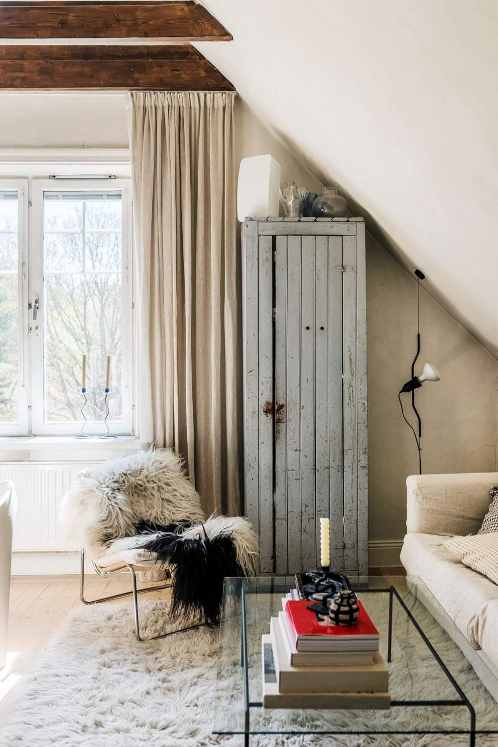 A Charming Attic Apartment with High Ceilings 7 neutral-living-room-slanted-ceiling-exposed-wooden-beams-nordroom