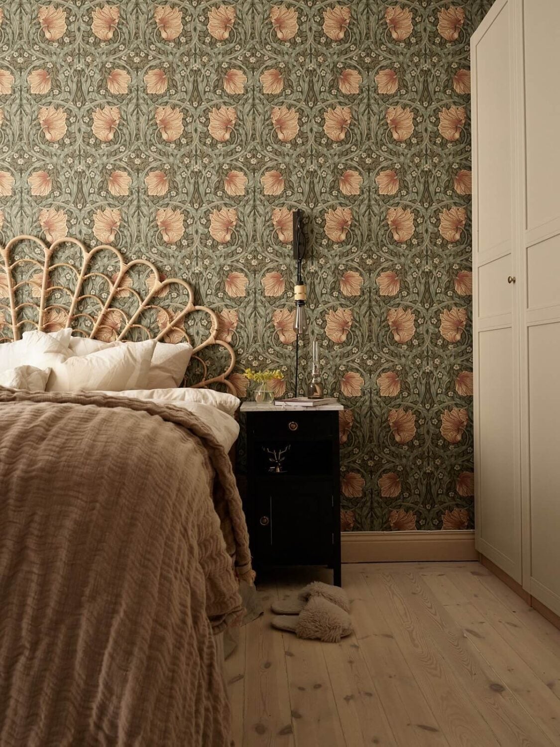 Warm Muted Colors in a Stockholm Apartment 15 rattan-headboard-william-morris-wallpaper-wardrobes-wooden-floor-nordroom