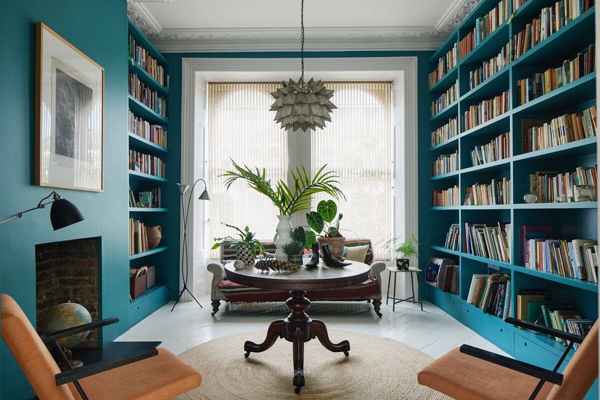 36 Home Library Ideas That Are A Book-Lover's Dream 1 reading-room-deep-teal-bookcases-fireplace-round-antique-table-nordroom