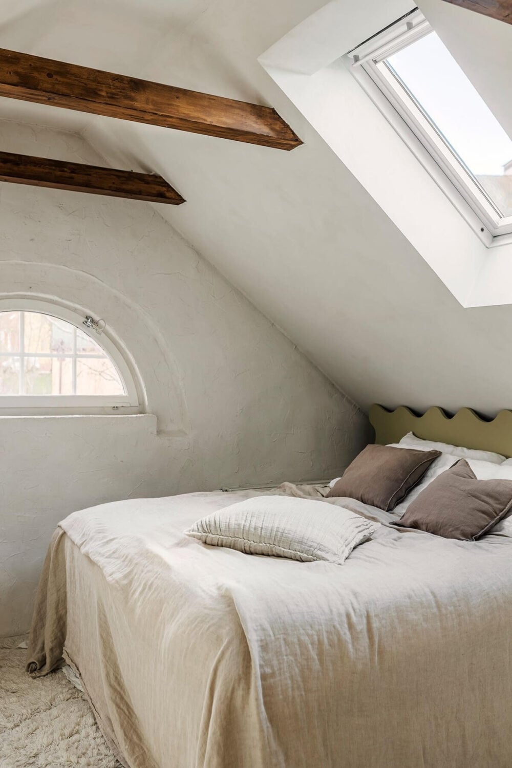 A Charming Attic Apartment with High Ceilings 17 serene-light-bedroom-wavy-headboard-wooden-beams-nordroom