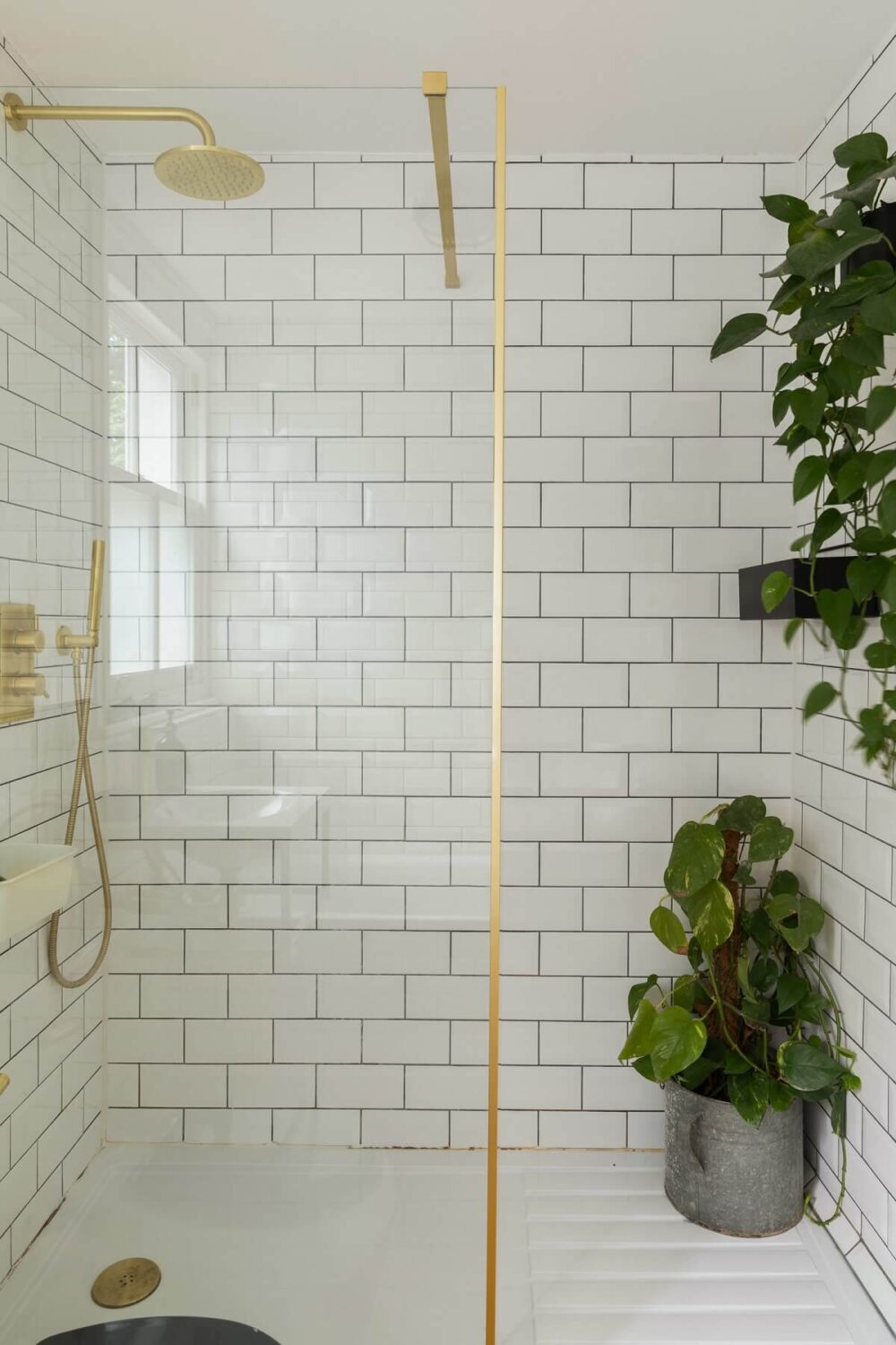 Colorful Rooms in a Family Home in London 21 small-bathroom-shower-white-subway-tiles-brass-fixtures-nordroom