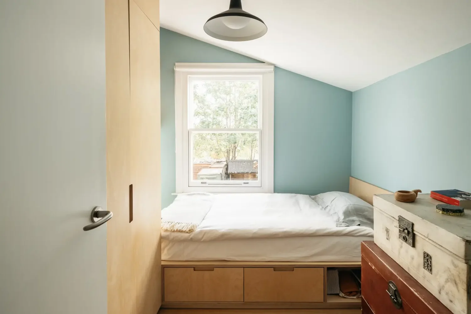 Modern Custom Interiors in a Victorian Home 11 small-bedroom-slanted-ceiling-blue-walls-storage-bed-nordroom