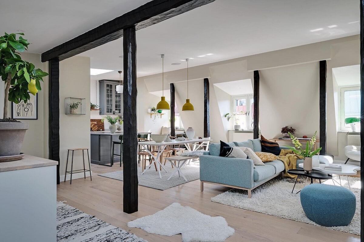 A Modern Scandinavian Attic Apartment 15 spacious-living-room-blue-sofa-wooden-beams-nordroom