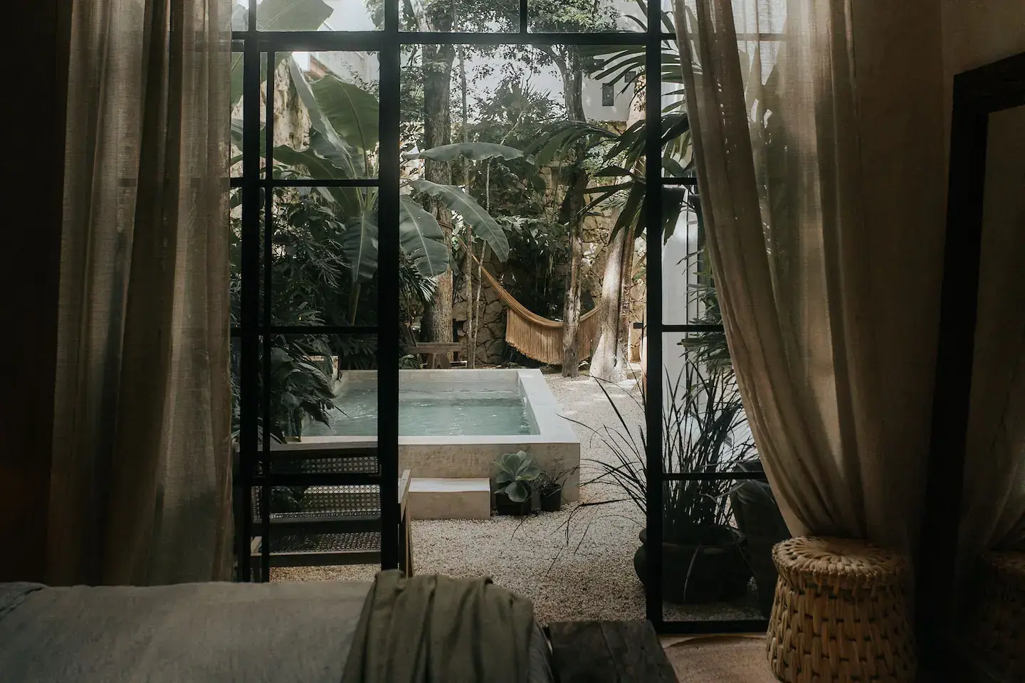 Rustic Wooden Elements in a Stylish Tulum Airbnb 22 steel-framed-glass-doors-bedroom-garden-swimming-pool-nordroom