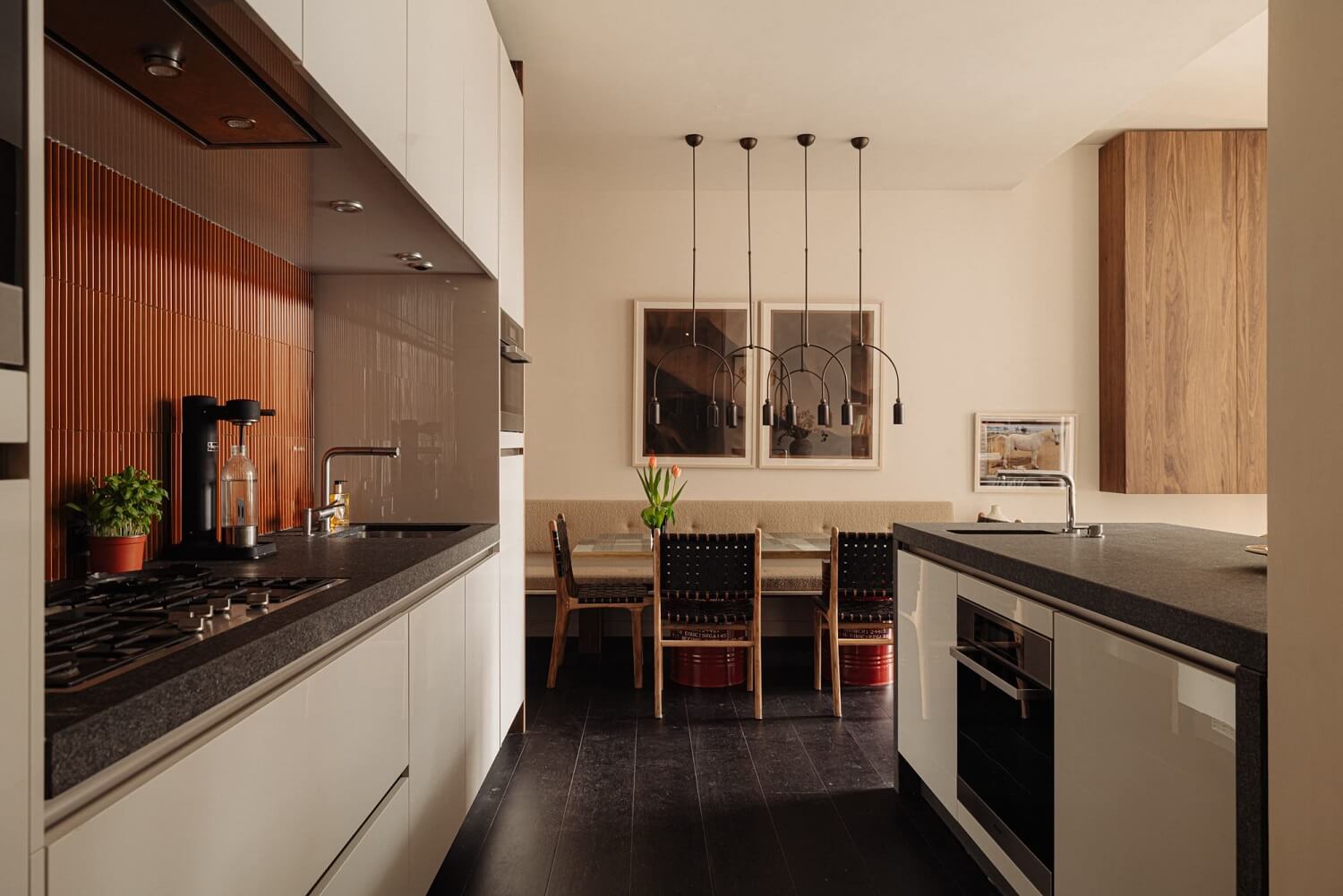 A Luxurious Duplex Apartment in Amsterdam 8 white-galley-kitchen-orange-textured-backsplash-dining-table-nordroom