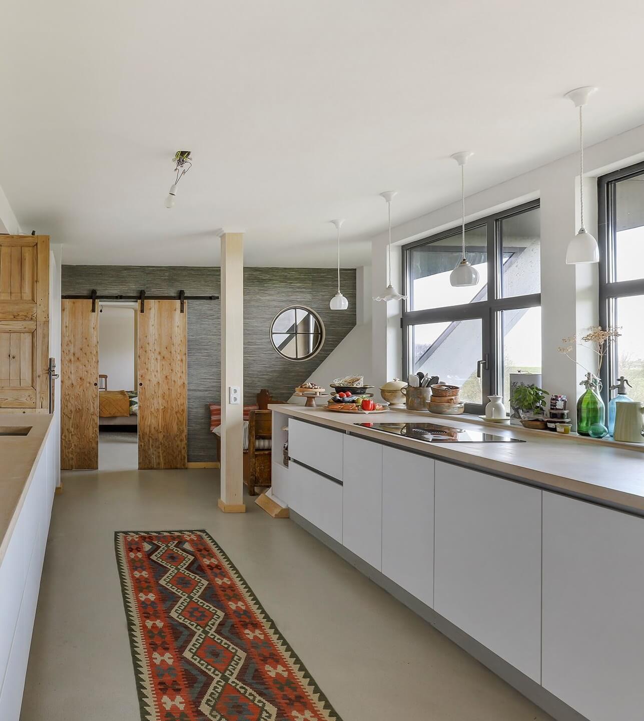 A Unique Upside Down House in The Netherlands 11 white-modern-galley-kitchen-sliding-wooden-doors-nordroom