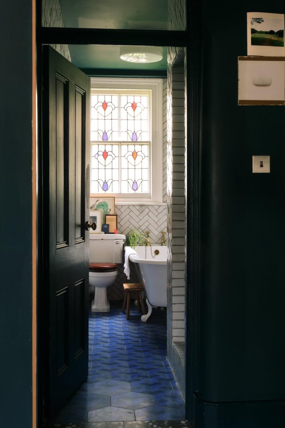 Bold Colors and Historic Details in a Victorian Apartment 15 bathroom-blue-floor-tiles-stained-glass-window-nordroom