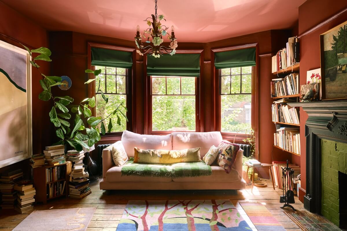 Bold Colors and Historic Details in a Victorian Apartment 4 bay-window-living-room-reddish-brown-walls-bookshelves-nordroom