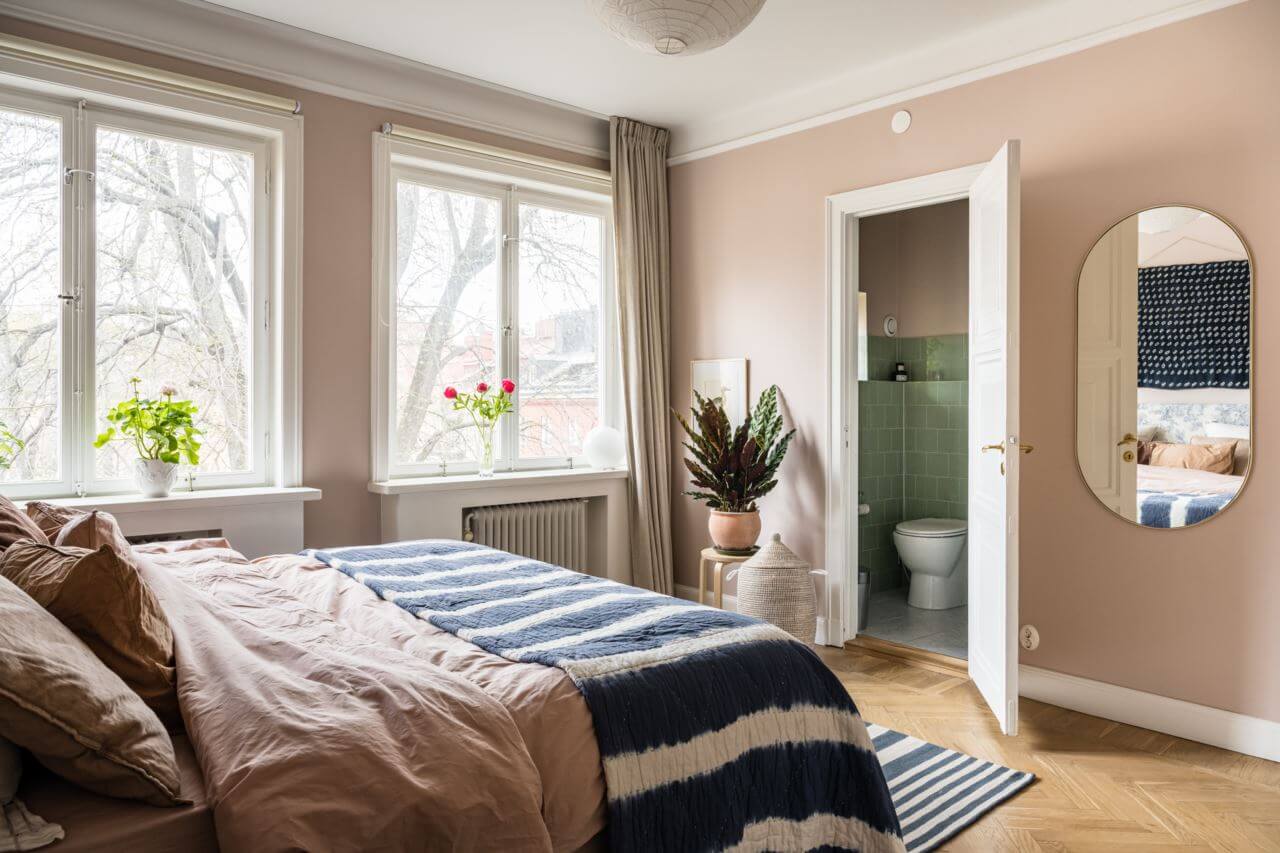 Green Color Accents in a Beautiful Historic Apartment 18 bedroom-pink-walls-blue-striped-throw-nordroom