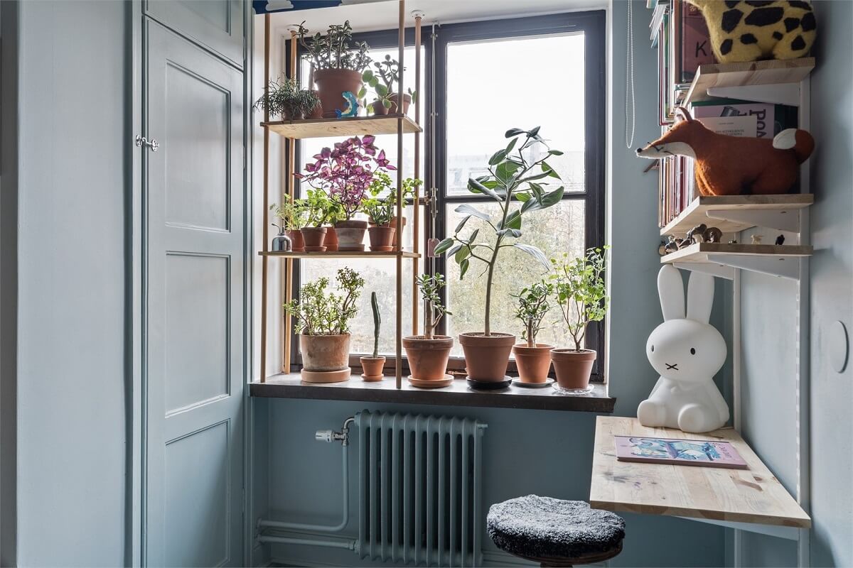 A Warm Scandinavian Apartment Filled with Books & Plants 15 blue-kids-bedroom-plants-desk-nordroom