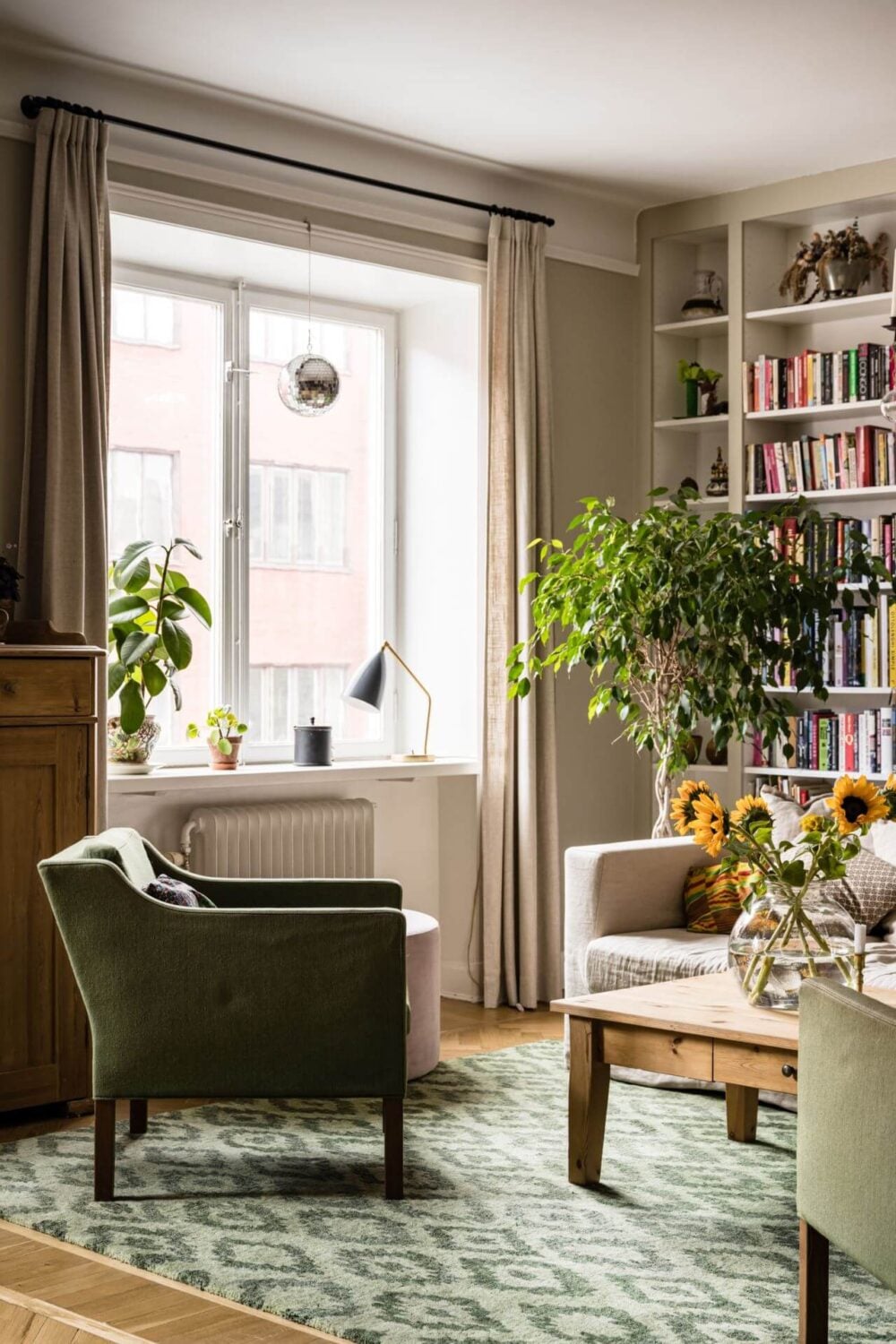 Green Color Accents in a Beautiful Historic Apartment 3 green-armchair-living-room-bookshelves-nordroom